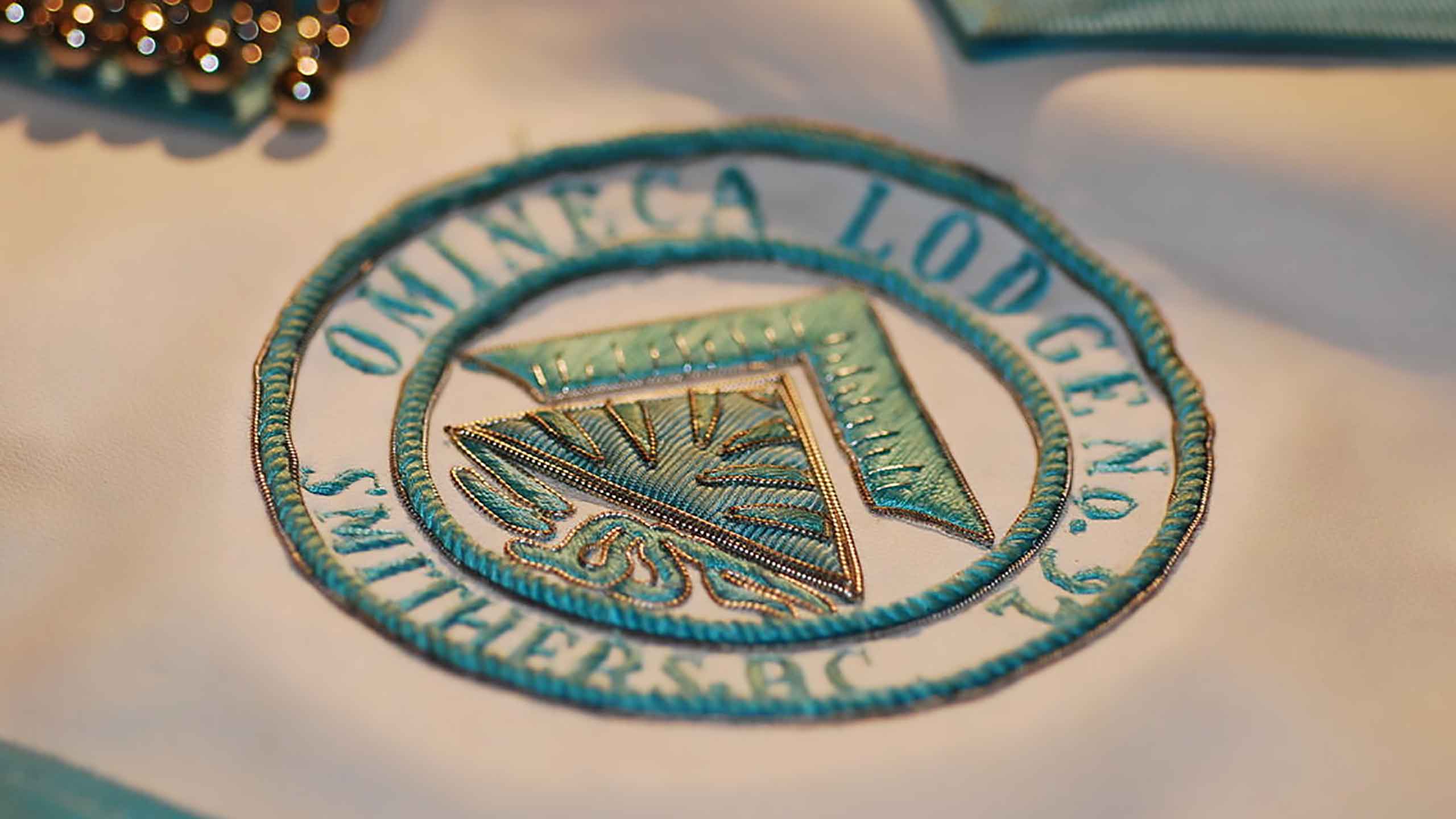 a photograph of a freemasons apron highlighting the omineca lodge 92 logo.